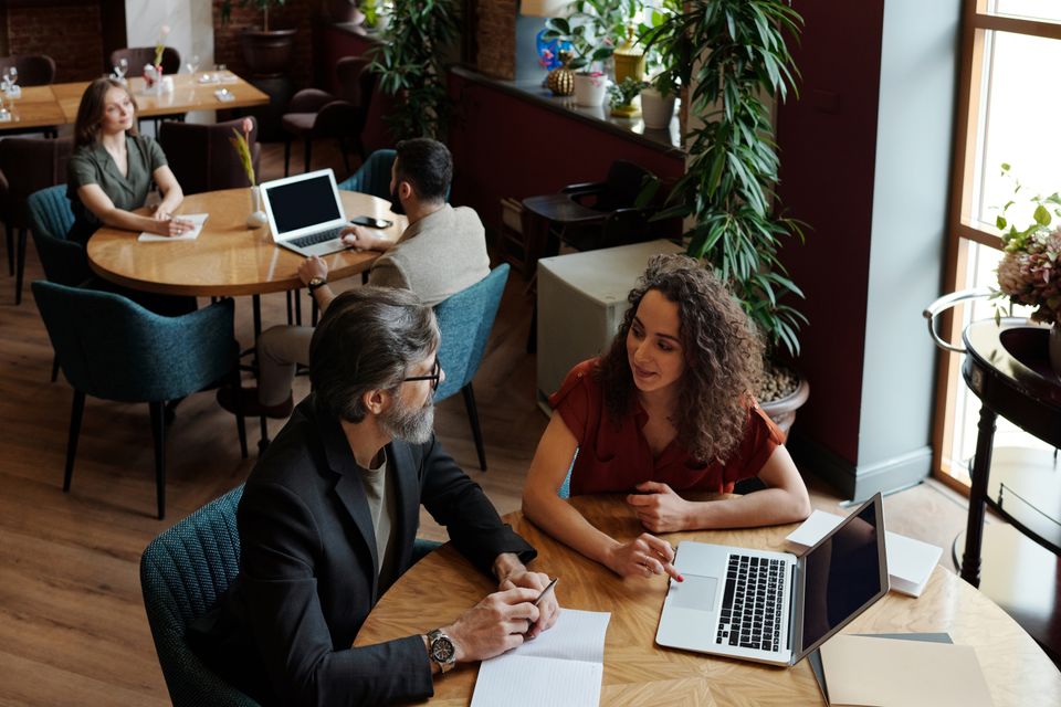 Two professionals discussing work at a café table