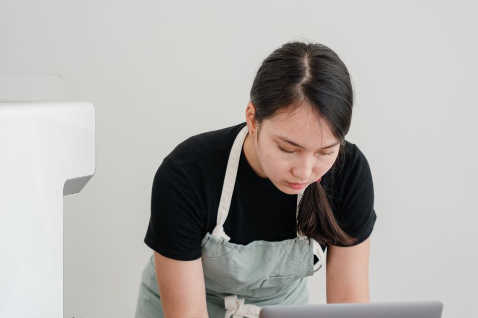 Barista reviewing information on a laptop in a coffee shop
