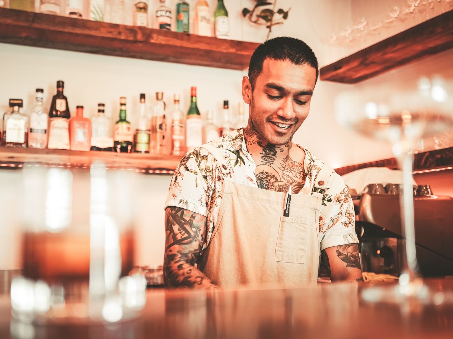 Bartender working behind a softly lit cocktail bar